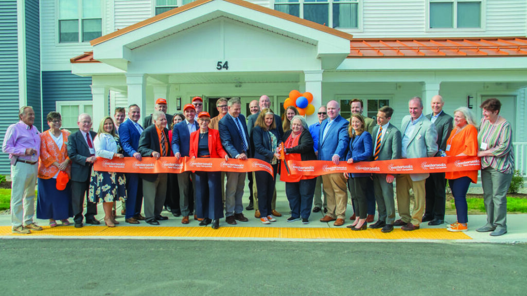 Group photo cutting the ribbon at Champlin Place.