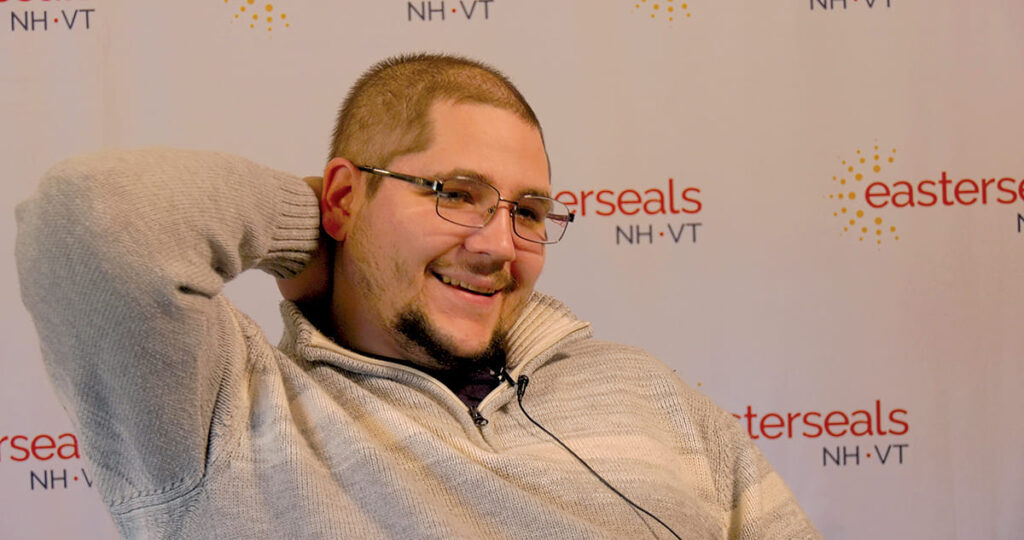 Mike being interviewed with Easterseals NH & VT step and repeat in the background.