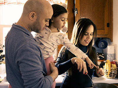 Father and mother cooking with daughter